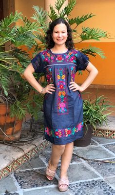 Beautiful denim dress embroidered by hand by artisans from the state of Oaxaca, Mx. comfortable and fresh, with lace details and drawstring to adjust at the waist. The embroidery is unique to each dress so it may vary. Mexican textile art has centuries of history and creativity throughout the country. Mexico is recognized as one of the leading countries with a beautiful artistic production in the textile world, miraculous hands of talented artisans from different states of the country create stu Fitted Cotton Dress With Embroidered Neckline, Cotton Dress With Floral Embroidery For Festival, Cotton Embroidered Dress With Floral Embroidery For Fiesta, Cotton Dress With Embroidered Hem For Fiesta, Traditional Fitted Dress For Cinco De Mayo, Folk Style Cotton Fiesta Dress, Folk Cotton Dress For Fiesta, Folk Style Cotton Dress For Fiesta, Bohemian Denim Dress With Floral Embroidery