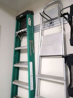 a green ladder next to a white wall and some other items on the shelf in front of it