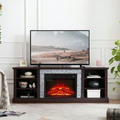 a flat screen tv sitting on top of a wooden stand next to a fire place