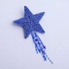 a blue and white star pin with beads on it