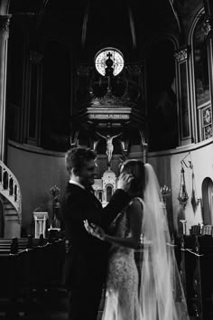 a bride and groom standing in front of the alter