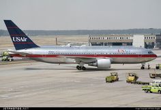 an airplane is parked on the tarmac with other vehicles around it and people near by