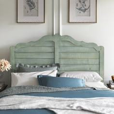 a bed with two pictures on the wall above it and a blue comforter in front