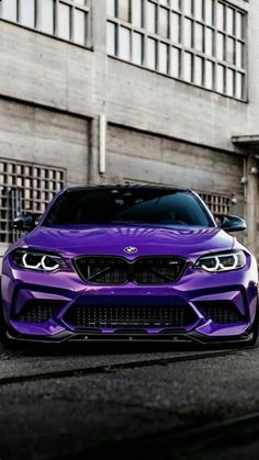 a purple bmw car parked in front of a building on the side of the road