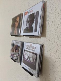 two cassette tapes are hanging on the wall next to each other, one has an album