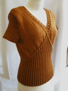 a mannequin wearing a brown sweater on top of a white dummy