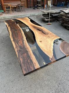 a table made out of wood and glass is shown in the middle of a parking lot