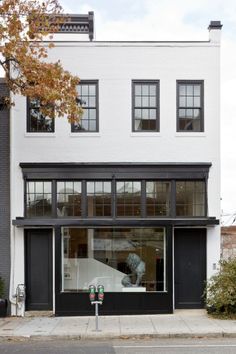 an image of a storefront with windows and black shutters on the front door