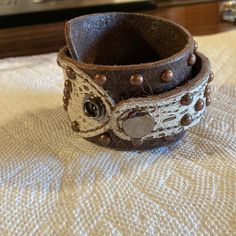 A Previously Owned New Without Tags Brown Studded Leather Cuff Bracelet. It Is 16” Long And Is 3/4”-2-3/4” Wide. It Has 2 Snaps For Easy Adjustment. A Great Addition To Your Leather Bracelet Collection. Thank You For Looking!!! Thick Leather Bracelet, Adjustable White Leather Bracelets, Adjustable Brown Cuff Jewelry, Brown Cuff Leather Bracelet, Adjustable Leather Wristlet, Brown Cuff Bracelets As Fashion Accessory, Brown Cuff Bracelet As Fashion Accessory, Unique Leather Cuff Bracelet, Adjustable Leather Bracelet With Snap Closure