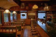 the inside of a restaurant with wooden tables and bar stools in front of windows