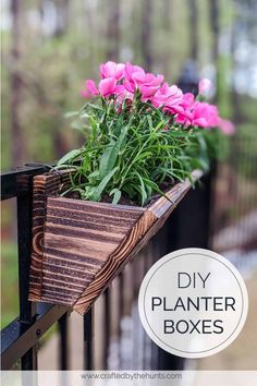 some pink flowers are in a wooden planter box on a railing with the words diy planter boxes above it