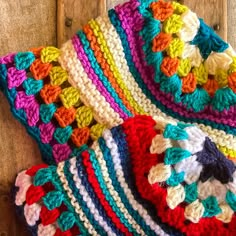 multicolored crocheted dishcloths on wooden surface