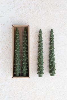 three small trees in a box on a table