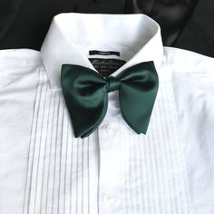 A modern, sleek satin pre-tied and adjustable oversized bowtie perfect for tuxedos and/or suits.   Color:  Hunter Green Material:  Satin Polyester Bow Tie:  approx. 4.75 inches wide and 4 inches height Matching Pocket Square:  approx. 9 inches by 9 inches www.tie-mood.com Elegant Green Tuxedo For Groom, Elegant Green Groom's Tuxedo, Classic Green Groom's Tuxedo, Elegant Solid Color Bow For Wedding, Classic Green Bow Tie For Business, Solid Wedding Tie With Satin Bow, Solid Color Wedding Tie With Satin Bow, Elegant Green Tie With Satin Bow, Dapper Tuxedo With Ties For Groom