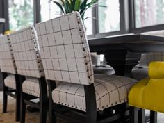 a dining room table with four chairs and a potted plant