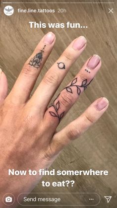 two fingers with tattoos on them, one has an arrow and the other has a heart