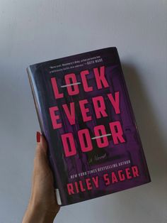 a person holding up a book with the title lock every door