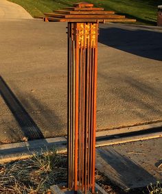 a tall metal pole sitting on the side of a road next to a grass covered field