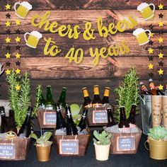 there is a table with beer bottles and plants in pots next to eachother