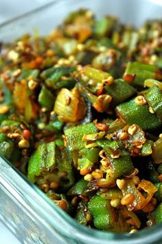 a glass dish filled with green beans and nuts