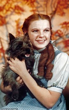 a woman holding a small dog in her arms