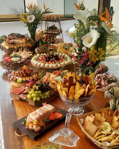 a wooden table topped with lots of different types of foods and desserts on top of it