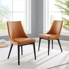 two brown chairs sitting next to each other on top of a white carpeted floor