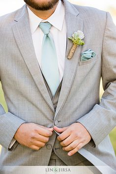 a man wearing a suit and tie with a boutonniere on his lapel