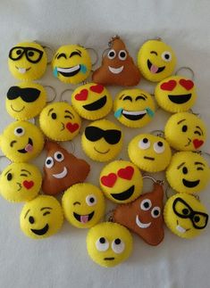 a bunch of yellow smiley face cupcakes on a white tablecloth with eyes, lips and hearts