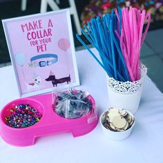 there is a pink tray with plastic straws and other items on it next to a sign that says make a collar for your pet