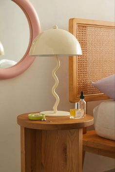 a table with a lamp on it next to a mirror