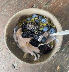 a bowl filled with yogurt and berries on top of a wooden table