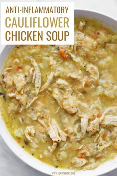 a white bowl filled with chicken soup on top of a table