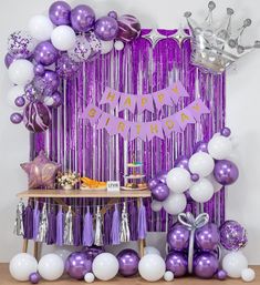 a purple and white birthday party with balloons, streamers, tassels and decorations