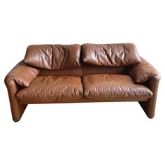 a brown leather couch sitting on top of a white floor