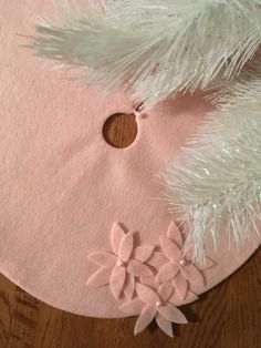 a white christmas tree skirt with pink felt flowers