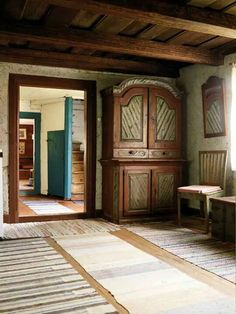 an empty room with wooden furniture and rugs