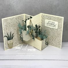 an open card with some plants in it