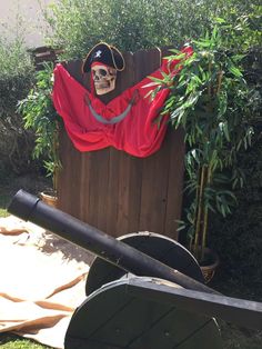 a pirate's chest with a red shirt on it and a black cannon in the foreground