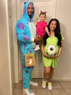 a man and woman in costume standing next to each other with a baby on their lap