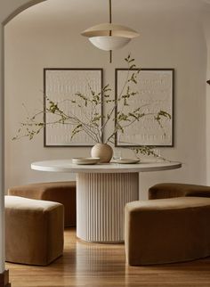 a dining room table with two chairs and a vase on it