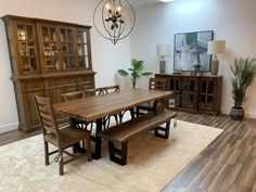 a dining room table and chairs in front of a china cabinet