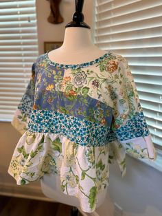 This is a handmade floral blouse sewn with nice blend of upcycled floral fabrics of blue, white, yellow and green colors. The fit of this blouse is an oversized/comfy style with a gathered peplum and wide cut sleeves. Measurements: width - 57 inches. Green Patchwork Cotton Blouse, Green Cotton Patchwork Blouse, Blue Cotton Tops With Floral Patchwork, Cotton Tops With Mixed Print, Green Cotton Blouse With Patchwork, Spring Green Patchwork Blouse, Blue Patchwork Relaxed Fit Blouse, Casual Cotton Blouse With Floral Patchwork, Blue Relaxed Fit Patchwork Blouse