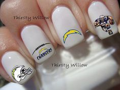 the nails are decorated with baltimore ravens and football helmets on them, as well as white nail polish