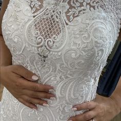 a close up of a person wearing a wedding dress and holding their hands on the waist