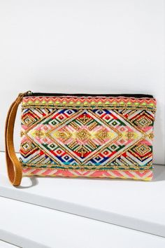 This beautiful handmade clutch features a yarn jacquard ethnic diamond-shaped pattern embroidered with beads and a leather wristlet clutch Great for small gifts Shell: 100% Cotton Trim: Suede Leather Lining: 100% Polyester Length 5.25" Width 8.50" Wristlet 7" Pouch Handmade in India Color: Multicolor Bohemian Multicolor Clutch With Zipper Pouch, Bohemian Beaded Pouch Clutch, Multicolor Summer Festival Clutch, Summer Festival Multicolor Clutch, Multicolor Woven Rectangular Clutch, Rectangular Woven Clutch For Festival, Bohemian Beaded Clutch For Everyday Use, Rectangular Beaded Clutch For Travel, Embroidered Multicolor Clutch Pouch