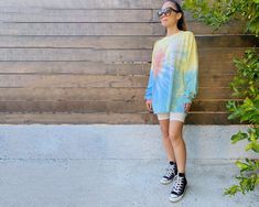 "Our long sleeve tie-dye top comes in two colors. The shirt comes in one size and is modeled on both a petite (5'2\"} woman and tall (6'1\") man. It's the perfect oversized fit on a smaller person that can be worn with biker shorts or belted as a dress. The Sunset colorway was designed with our hometown of Los Angeles in mind. Sizing: One Size (Men's large) Care: Machine wash with like colors; tumble dry low" Casual Tie-dye Tops For Loungewear, Tie Dye Tops For Spring Loungewear, Casual Tie Dye Tops For Loungewear, Spring Tie-dye Tops For Loungewear, Spring Tie Dye Tops For Loungewear, Soft-washed Tie Dye Tops For Loungewear, Trendy Tie Dye Long Sleeve Top, Trendy Tie Dye Top For Loungewear, Trendy Tie Dye Loungewear Top