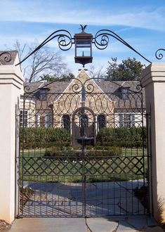 an iron gate in front of a large house