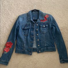 a denim jacket with embroidered roses on it