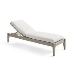 an outdoor chaise lounge chair with white cushions and wood frame, viewed from the side